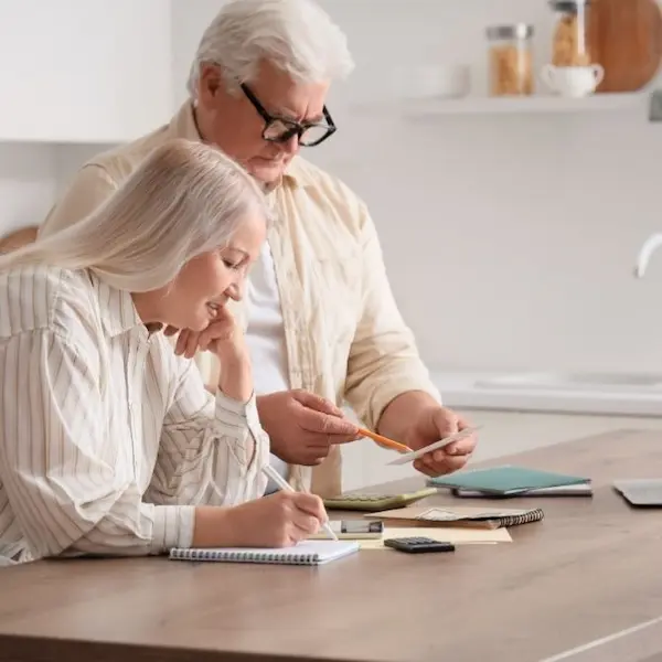 Pareja de adultos mayores analizando su situación financiera con el respaldo de Expertos en Pensión de Invalidez y Sobrevivencia en Colombia.