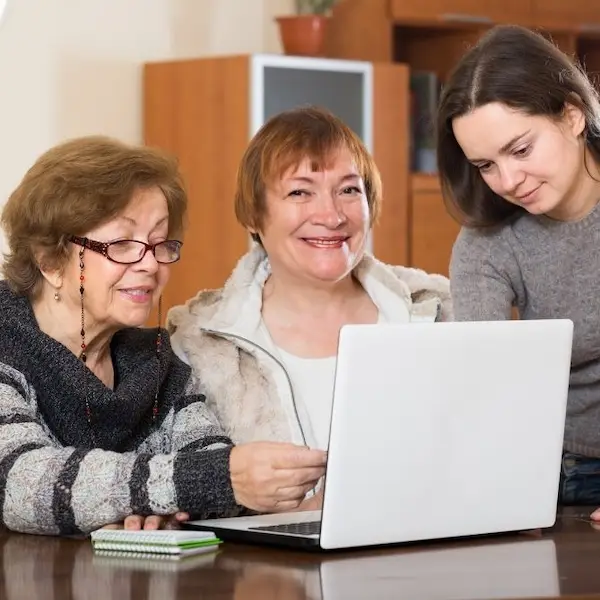 Devolución aportes pensiones Colombia: tres mujeres de distintas generaciones revisando juntas el diagnóstico de sus ahorros pensionales en una laptop.